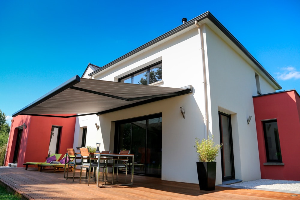 maison moderne, terrasse en bois et store banne